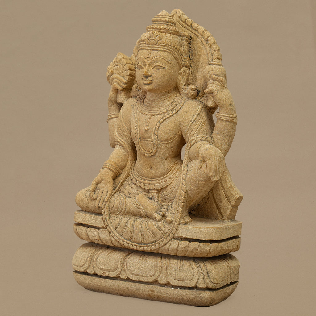 Right angle view of handcrafted 12 inch Lord Vishnu statue carved from yellow sandstone